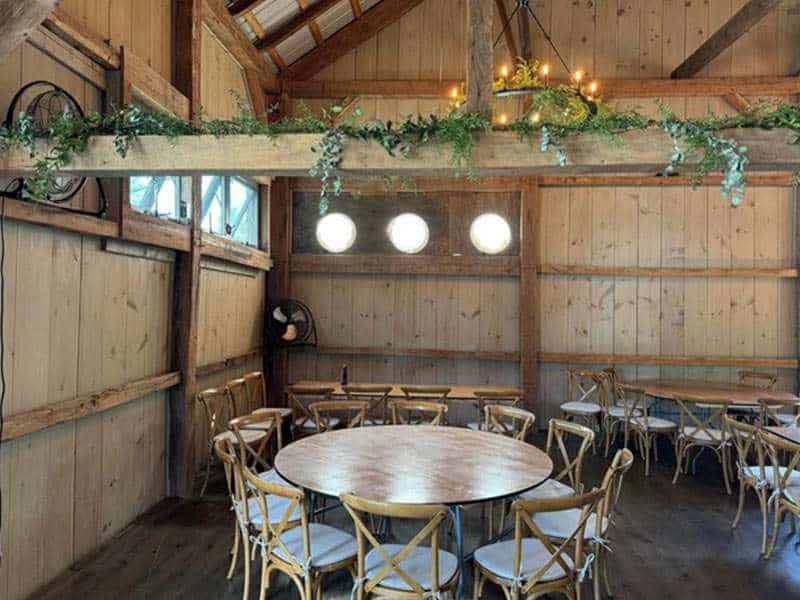 Charming rustic barn event space with wooden decor and elegant lighting for rent.