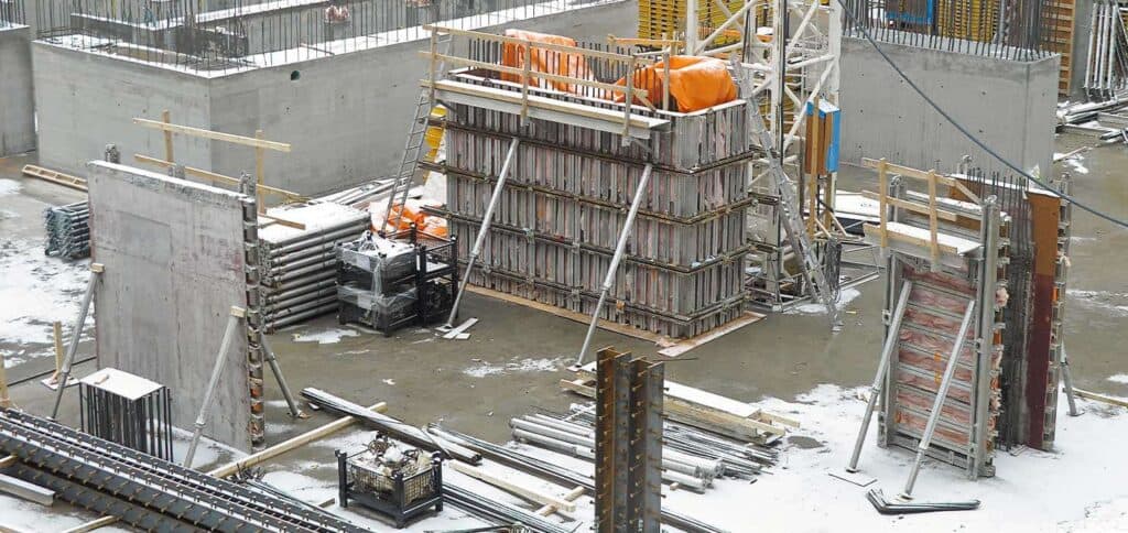 Steel reinforcement and concrete formwork on a construction site for rental property development.