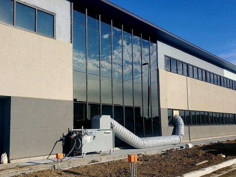 Modern commercial building with glass exterior and HVAC system for rent or lease.