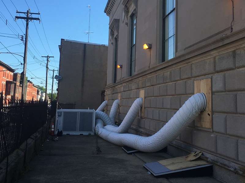 1. Large HVAC ductwork installation outside a building for rental property ventilation.