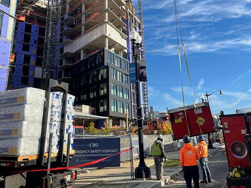 Construction site with modern building and safety workers, showcasing urban real estate development.