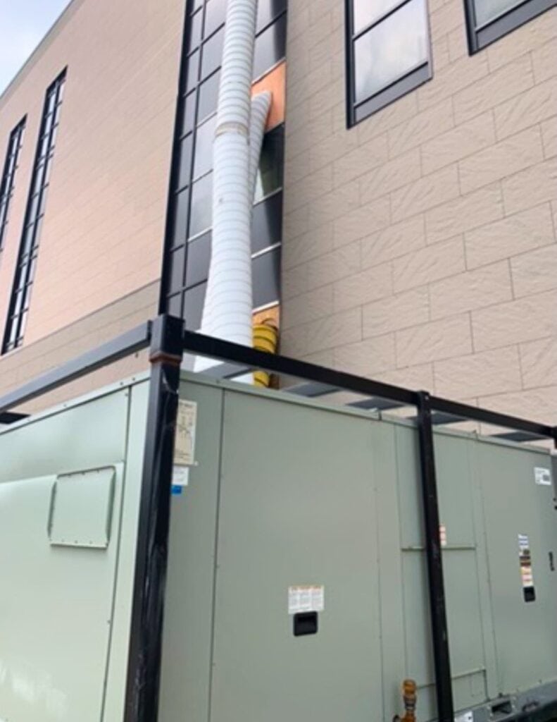 Flexible HVAC system installation on modern building exterior for rental properties.