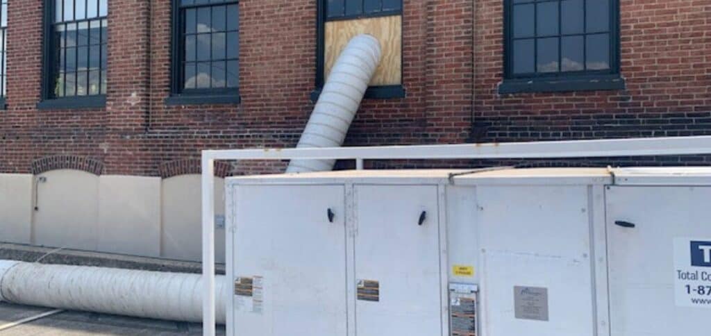 Disused building with construction ductwork and equipment, possibly under renovation or maintenance.