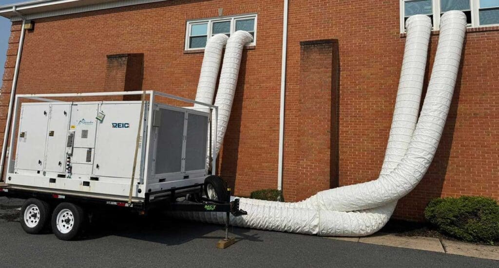 1. Mobile HVAC unit with ducting outside brick building for climate control.