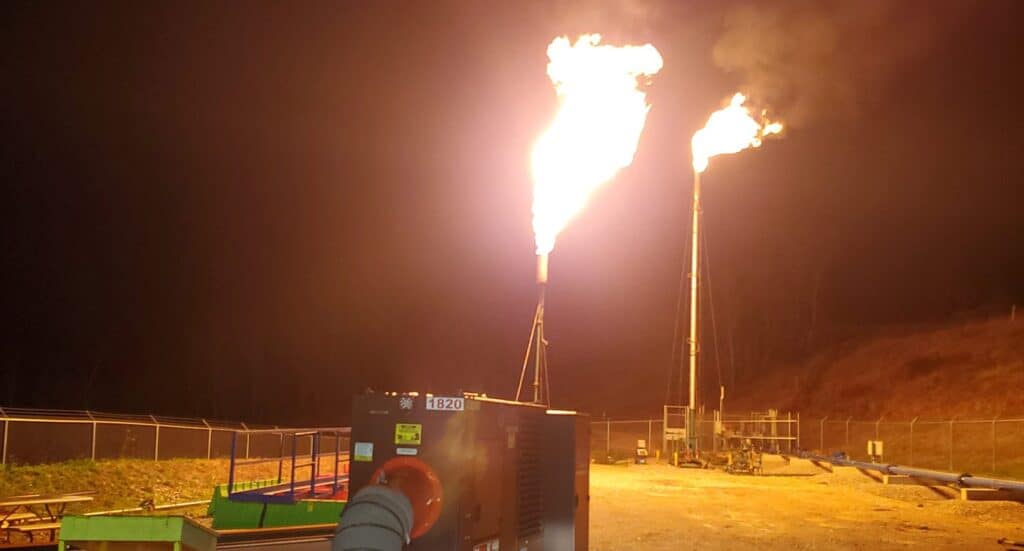 Flare stacks at oil or natural gas facility during night time.