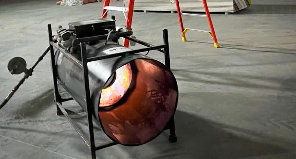 Bright construction work light on concrete floor at job site, portable lighting equipment included.