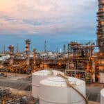 Oil refinery industrial plant with tanks and pipes at dusk, energy, and petrochemical industry focus.