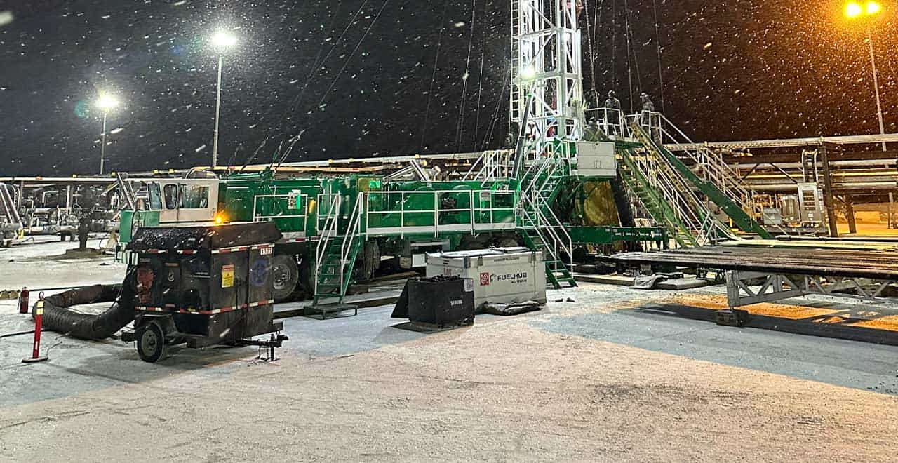 Heavy-duty oilfield drilling rig equipment at night, snow, cold weather, industrial setup, REIC Rentals Rentals.