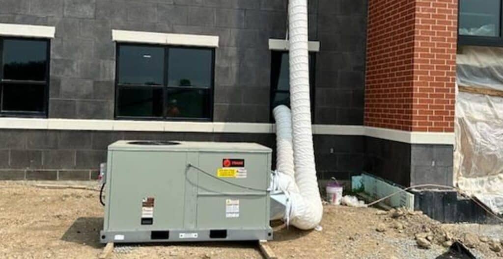Energy-efficient HVAC outdoor unit for rental property, under construction.