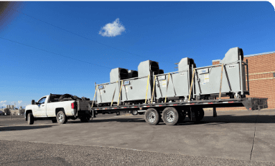 Large truck transporting industrial HVAC units for rental or installation.