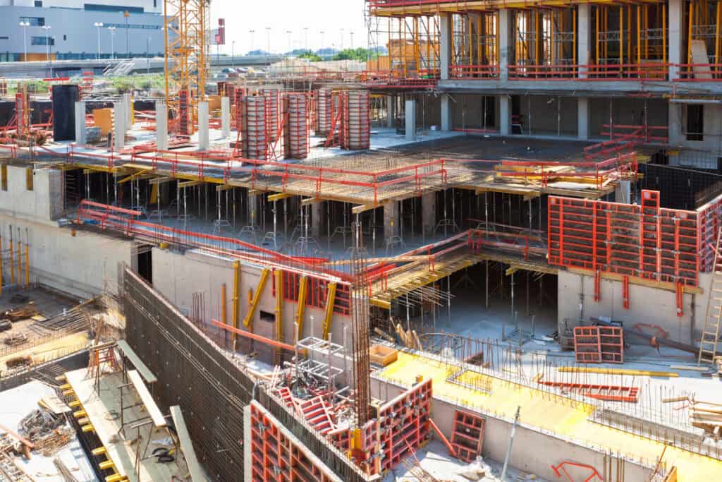 1. Construction site of residential building with steel framing and scaffolding.