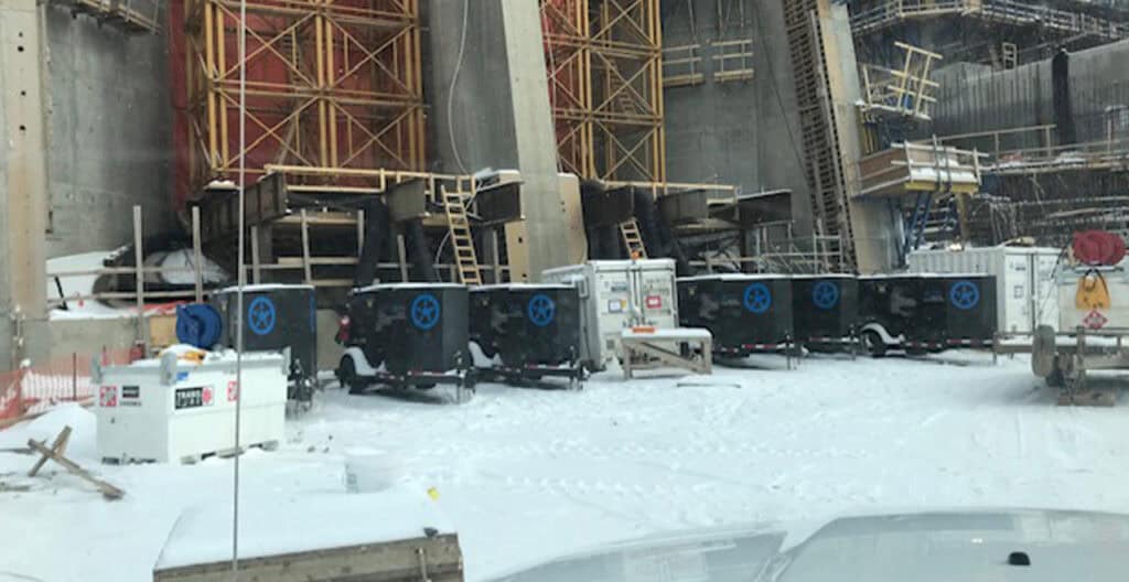 Construction site with snow, temporary waste and equipment, focusing on industrial and rental utility.