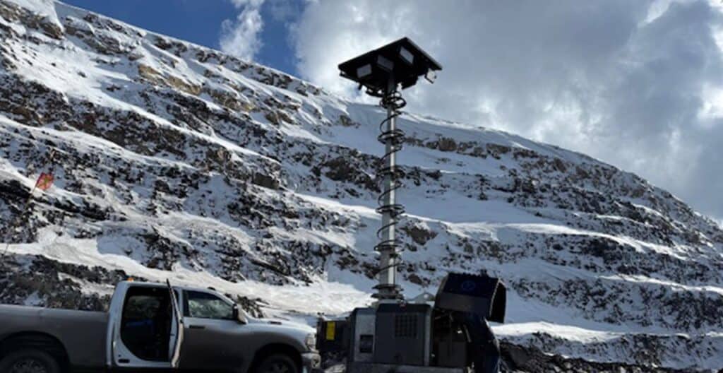 Mobile hybrid light tower on snowy mountain site for winter construction lighting.
