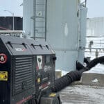 REIC Rentals industrial equipment on rooftop with HVAC systems and piping.