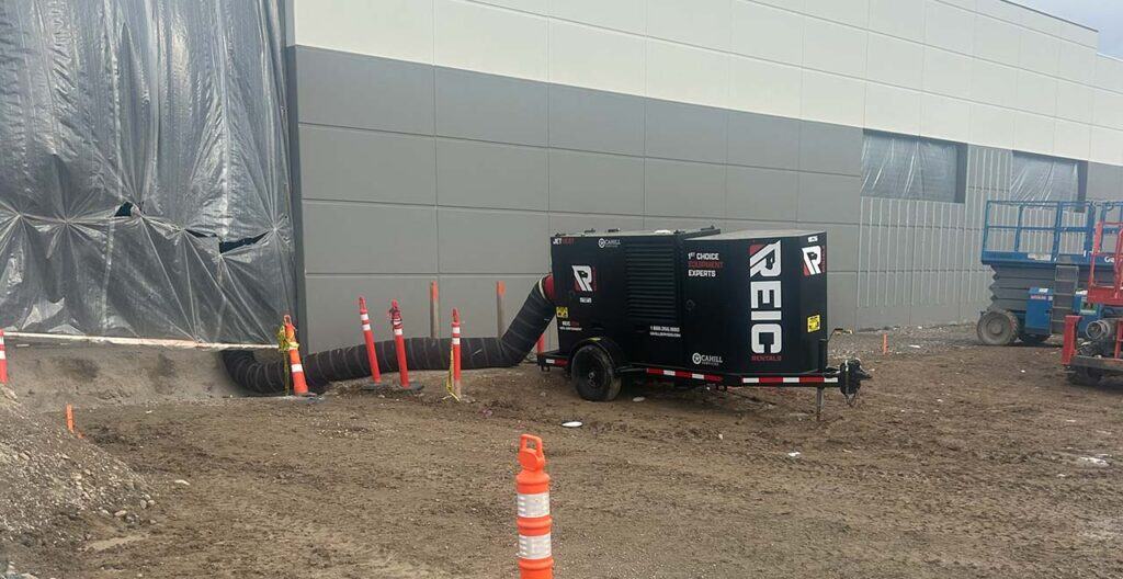 Portable concrete curing heater and equipment at construction site.
