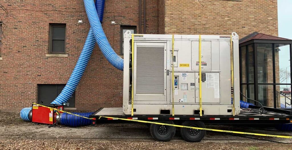 Industrial dehumidifier unit with blue hoses for moisture control.