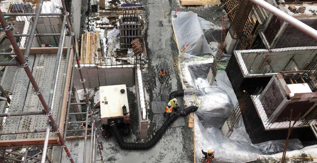 Construction workers preparing site with equipment and materials for turnaround season.