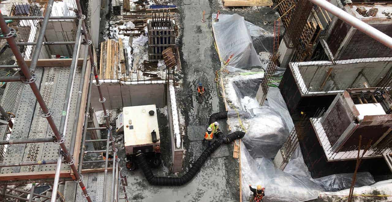 Construction workers preparing site with equipment and materials for turnaround season.