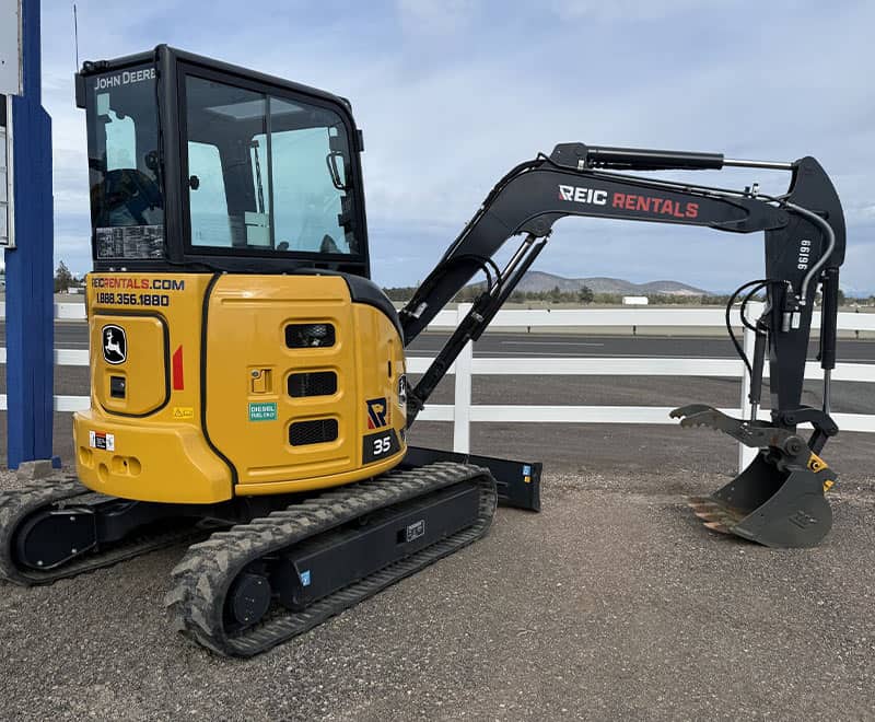 Mini excavator with REIC Rentals branding, suitable for small construction projects.