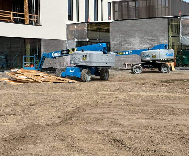 Genie boom lift and scissor lift on a construction site.