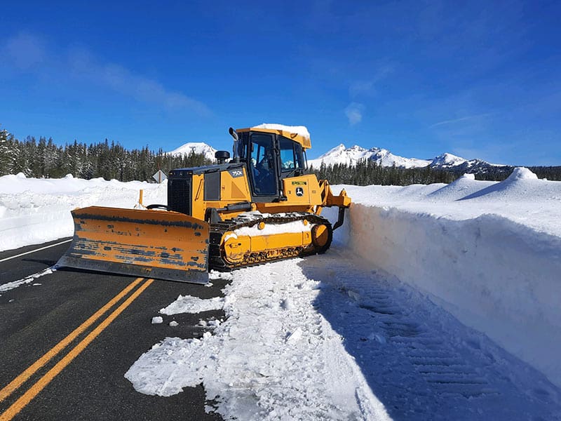 Snow plow clearing snow from a mountain road in Bend, Oregon.