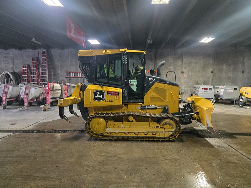 Bulldozer rental equipment at REIC Rentals in Bend, Oregon, showcased in an indoor storage facility.