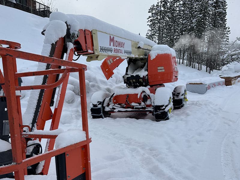 Cherry picker with snow on it at REIC Rentals, Bigfork location.
