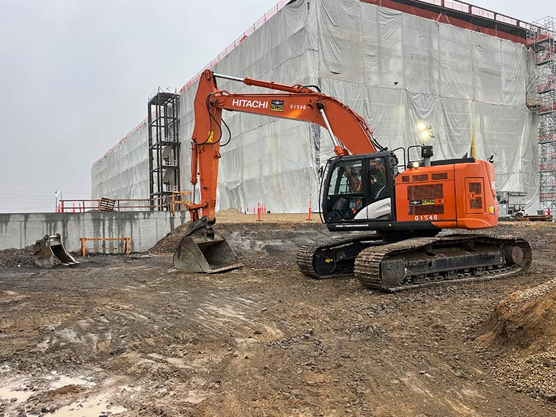 Excavator working on the foundation of a new building at REIC Rentals, Boise.