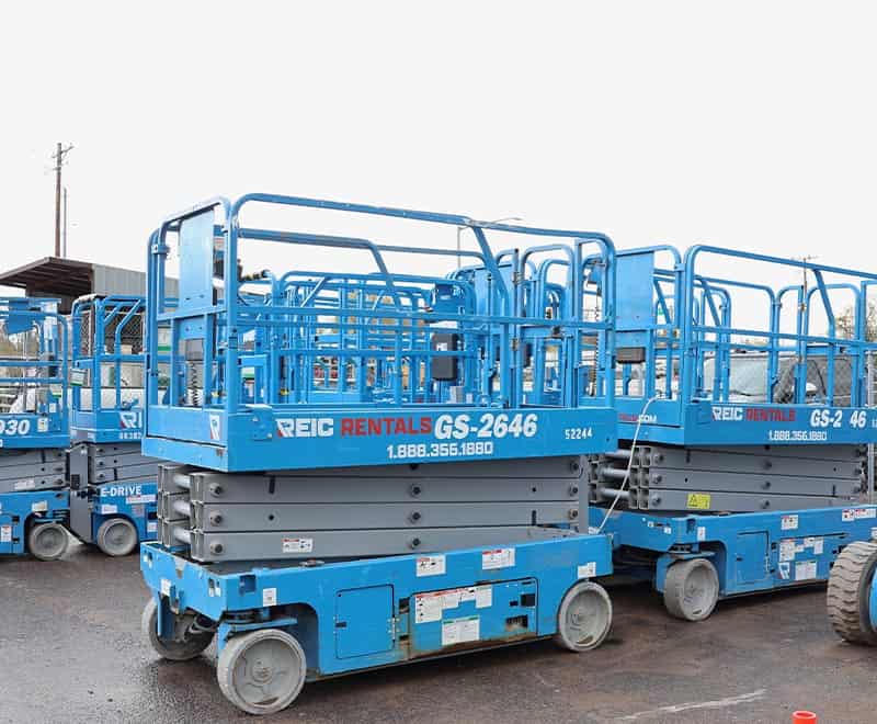 Blue scissor lifts available for rent at REIC Rentals for construction and maintenance projects.