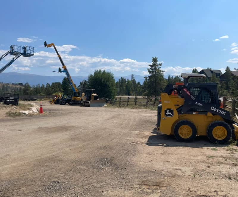 Construction equipment at REIC Rentals site, preparing for building development.