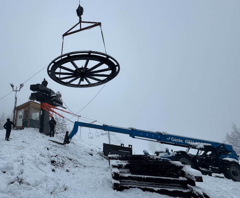 Ski lift wheel being installed on a snowy mountain at REIC Rentals.
