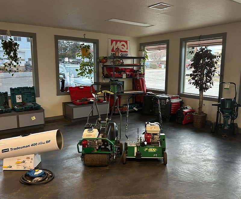 Equipment storage room with landscaping tools and machinery.