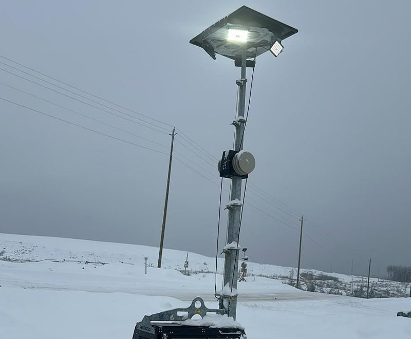 Solar-powered outdoor lighting system installed in snowy landscape for energy-efficient illumination.