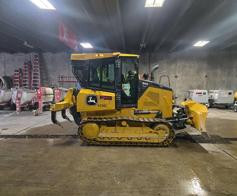 Bulldozer rental for construction projects at REIC Rentals, indoor storage facility.