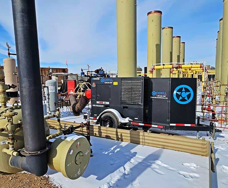 Industrial gas compression equipment at REIC Rentals site with pipes and machinery.