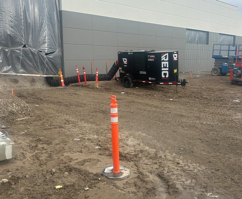 Portable industrial air compressor at construction site for rental services.