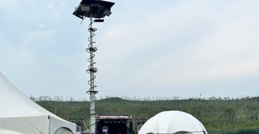 Mobile solar-powered lighting tower at outdoor event site.