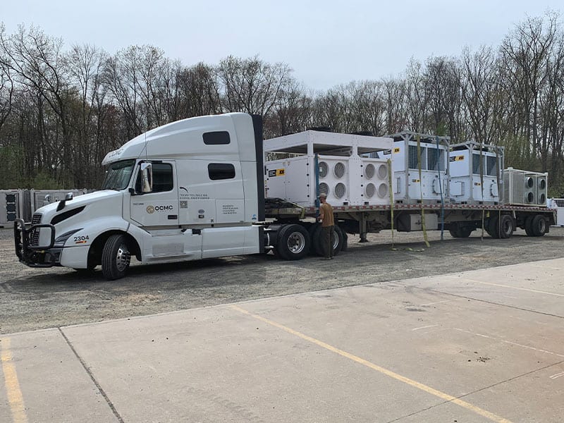Mobile modular units on flatbed truck for rental or transport services.