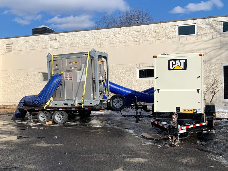Mobile industrial air filtration system with CAT generator on a parking lot.