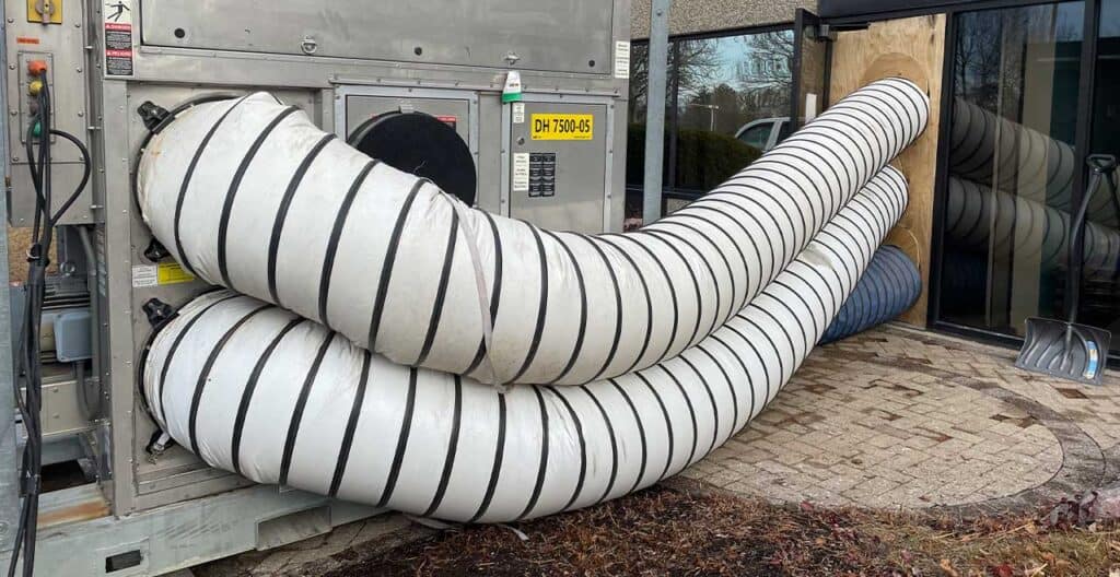 Large flexible HVAC ducting system outside commercial building for cooling.