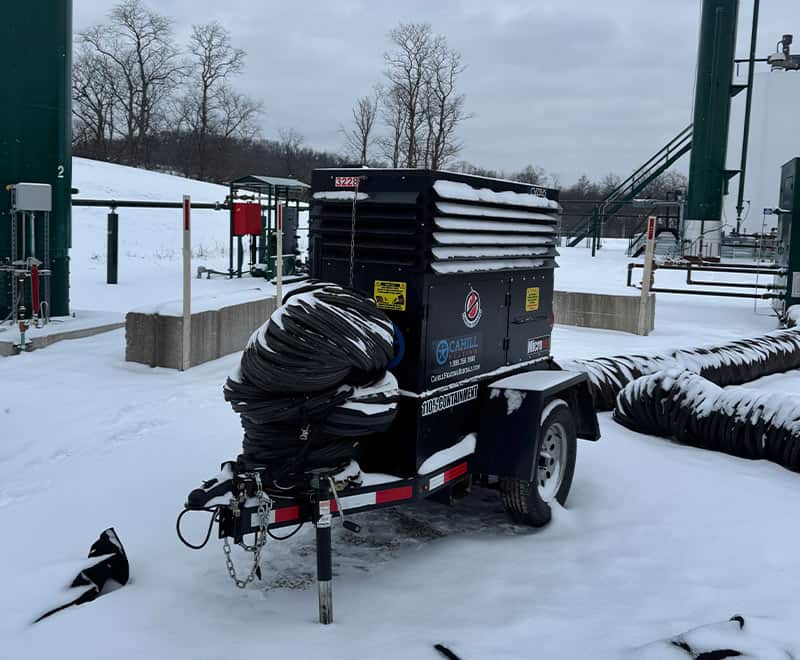 Portable equipment trailer with snow-covered hoses at Morgantown site.
