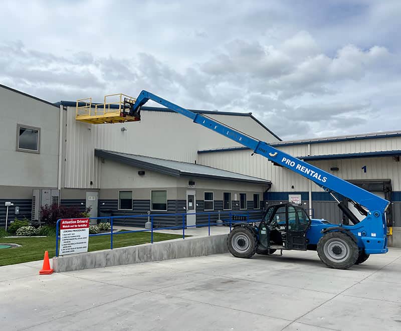 Blue boom lift at Ontario rental facility for construction work.