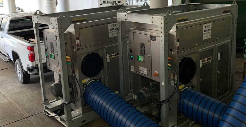 Industrial dehumidifiers used for drying water-damaged warehouse spaces.