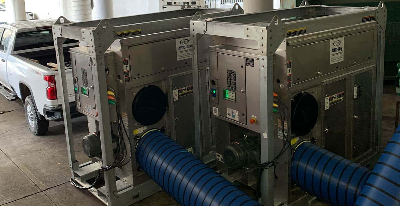 Industrial dehumidifiers used for drying water-damaged warehouse spaces.