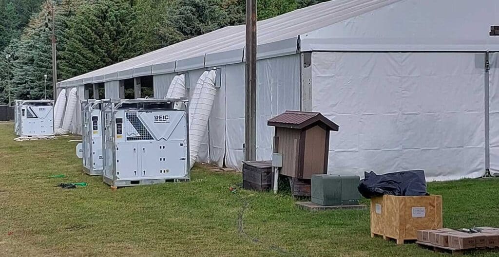 Large white hurricane preparedness tent with HVAC units outside.