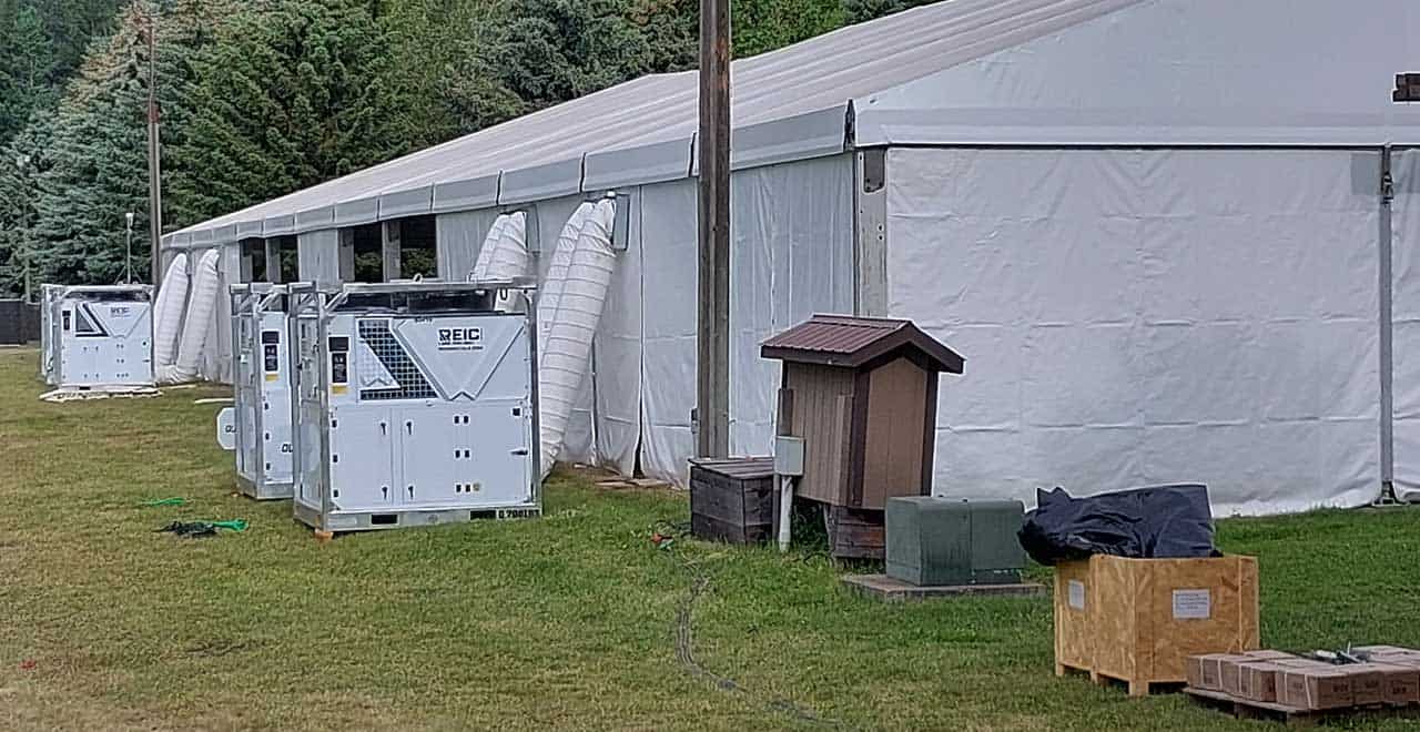 Large white hurricane preparedness tent with HVAC units outside.
