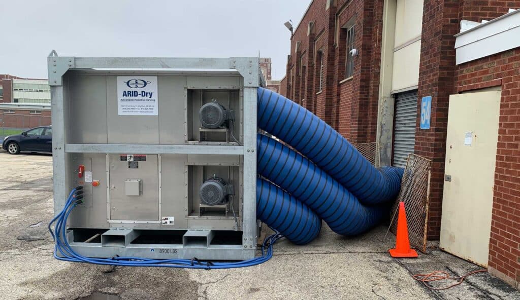 Industrial moisture control system with blue hoses for concrete curing.