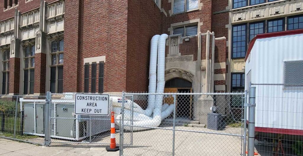 Construction area with HVAC ductwork and safety fencing.