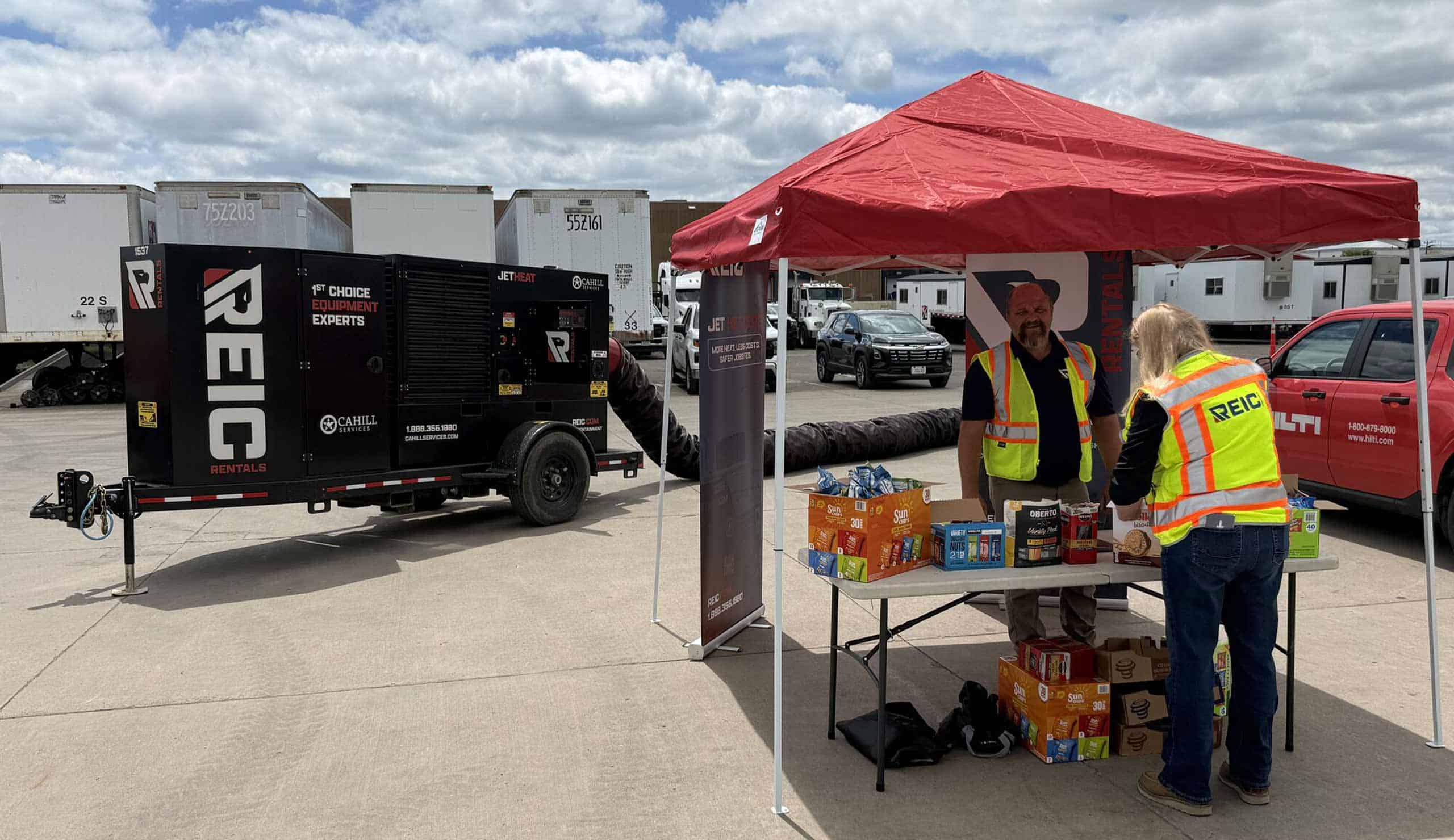REIC Rentals portable generator and staff at outdoor event.