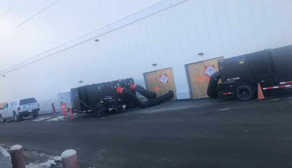 Industrial climate control units connected to a building for server room cooling.